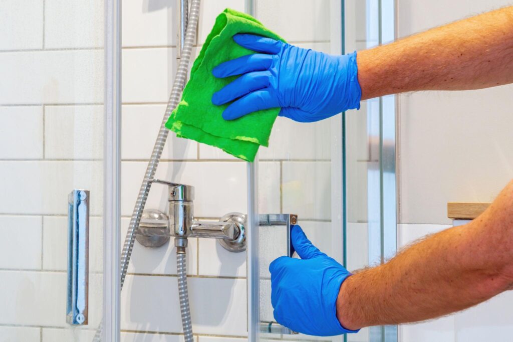 Worker Cleaning Bathroom Shower in Rutland