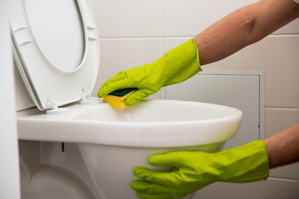 Worker Cleaning Toilet in Paxton